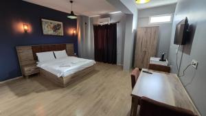 a bedroom with a bed and a tv and a table at Elizim Otel in İzmir