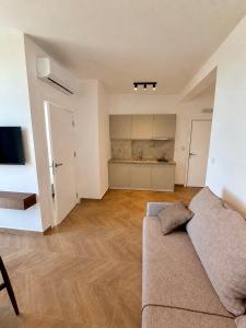 a living room with a couch and a kitchen at Maresa 1 in Čanj