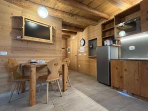 a kitchen and dining room with a table and a tv at Casa Vacanze Ranuncolo 4 in Sùtrio