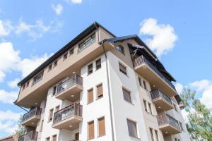 a tall white building with balconies on it at Apartman Sinisa in Zlatibor