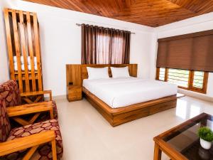a bedroom with a bed and a chair and a table at Babutaal Resort in Chakrāta