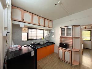 a kitchen with a black refrigerator and orange cabinets at My second home at Nashik in Nashik