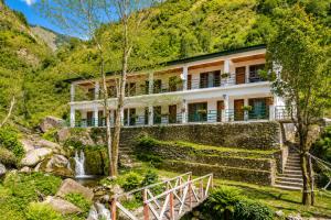 a house in the mountains with a waterfall at Babutaal Resort in Chakrāta
