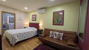 a living room with a bed and a couch at Arouca Passadiços Alojamento & Jacuzzi - SPA in Arouca
