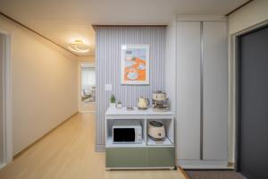 a room with a kitchen with a microwave at 선스테이 in Ilsan-ni