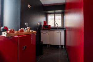 a kitchen with a red refrigerator and a sink at Le Cocon secret - Sauna - Jacuzzi in Quimperlé +15 photos