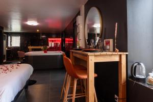 a room with a bed and a table with a mirror at Le Cocon secret - Sauna - Jacuzzi in Quimperlé