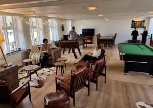 a group of people sitting in a room with pool tables at Gram Slot in Gram