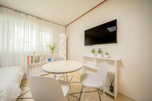 a room with a table and chairs and a tv at 선스테이 in Ilsan-ni