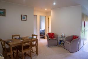 a living room with a table and chairs and a bedroom at Minffordd Cottage in Feilding