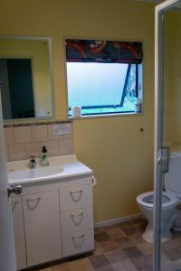 a bathroom with a sink and a toilet and a window at Minffordd Cottage in Feilding +9 photos