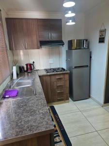 a kitchen with a sink and a refrigerator at One Bedroom Apartment B in Kempton Park