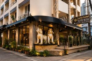 a store front of a building with two statues of cats at Collection O Luna Hotel Pattaya in Pattaya