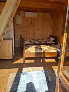 a room with two beds in a wooden cabin at Kukaj Apartments in Gusinje