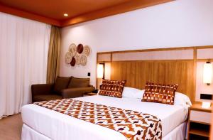 a hotel room with a large bed and a chair at Hotel Riu Touareg - All Inclusive in Curral Velho