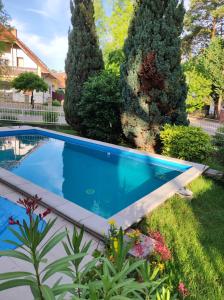 a swimming pool in a yard with trees at Aquasol Apartman in Siófok