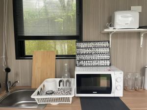 a kitchen with a microwave and a sink at Mountain Calm Inns in Xiayun