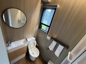 a bathroom with a toilet and a sink and a mirror at Mountain Calm Inns in Xiayun +3 photos
