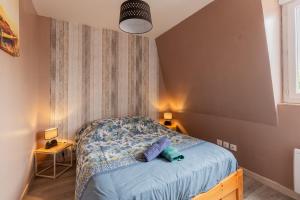 a small bedroom with a bed with blue sheets at Gîte Escale En Baie De Somme in Saint-Blimont