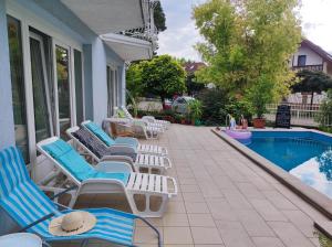 a patio with lounge chairs and a swimming pool at Aquasol Apartman in Siófok +52 photos