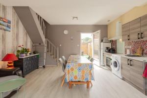a kitchen with a table and a dining room at Gîte Escale En Baie De Somme in Saint-Blimont