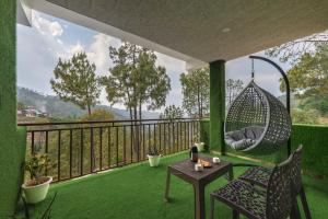 a room with a hammock on a balcony with green grass at TreeHouse Kasauli Operated By Splendid Hotels I Vacations I Family Groups & Events I Forest Treks I Memories I in Kasauli