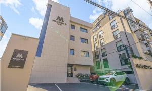 a building with a car parked in front of it at Pohang Mansion 6 Hotel in Pohang