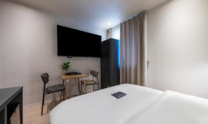 a hotel room with a bed and a desk and a tv at Pohang Mansion 6 Hotel in Pohang