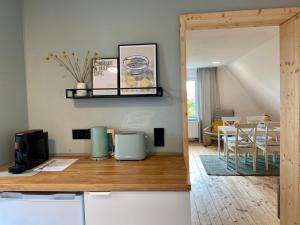 a kitchen and living room with a table and chairs at Ferienwohnung Weitblick in Bad Schussenried