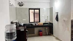 a kitchen with a sink and a counter with a window at PnH Stays in Siliguri +7 photos