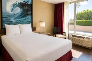 a hotel room with a bed and a large window at Kings Inn Anaheim at The Park & Convention Center in Anaheim +13 photos