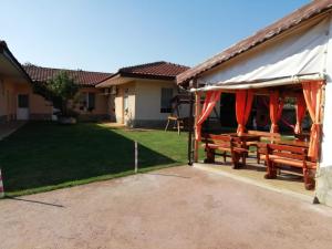 a pavilion with two benches in a yard at Guesthouse MIRAJ - SHABLA in Shabla