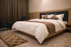 a bedroom with a large bed with white sheets and pillows at Maa Trinayani Palace in Katra +17 photos