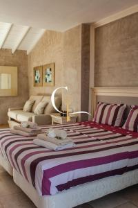 a bedroom with a large bed with purple and white stripes at Casa Lucia in Palm-Mar +89 photos