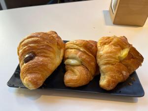 two croissants on a black plate on a table at B&B MariLù in Foggia
