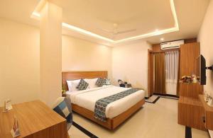 a hotel room with a bed and a desk at Heyday INN in Pathanāmthitta