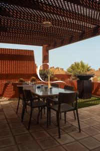a dining table and chairs under a pergola at Casa Lucia in Palm-Mar