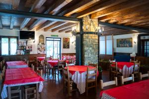 a restaurant with red tables and chairs in a room at Agriturismo Cascina del Vai in Cairo Montenotte