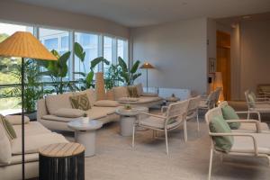 a waiting room with couches and chairs and windows at Hotel Punta in Vodice