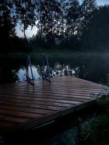 a dock on a body of water with trees at Lux Glamping, Lammas in Halliste