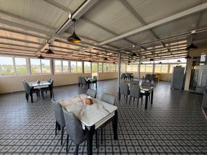 a dining room with tables and chairs and windows at Golden Suites in Bangalore