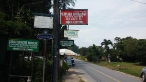 a street with signs on the side of a road at Wattana Bungalow in Nai Yang Beach