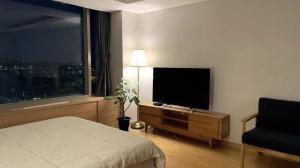 a bedroom with a bed and a flat screen tv at Self Check-in Only Residence near Incheon Airport T1 & Paradise City in Incheon