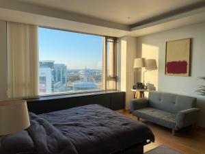 a bedroom with a bed and a couch and a large window at Self Check-in Only Residence near Incheon Airport T1 & Paradise City in Incheon