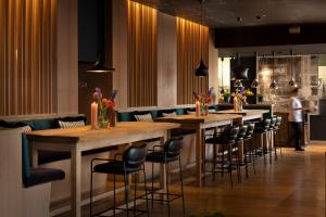 a bar with stools and tables in a restaurant at Das Traunsee - Das Hotel zum See 4 Stern Superior in Traunkirchen