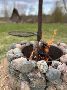 a fire pit with rocks and a grill at Lux Glamping, Lammas in Halliste