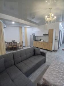 a living room with a couch and a table and a kitchen at Квартира возле стадиона in Kobuleti
