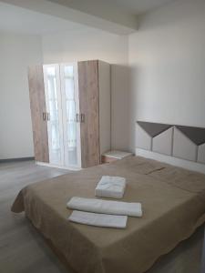 a bedroom with a large bed with towels on it at Квартира возле стадиона in Kobuleti