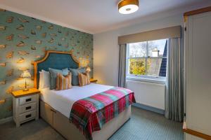 a bedroom with a bed with a bird wallpaper at Plockton Inn, by Highland Coast Hotels in Plockton