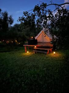 a tent with lights in a field at night at Lux Glamping, Lammas in Halliste